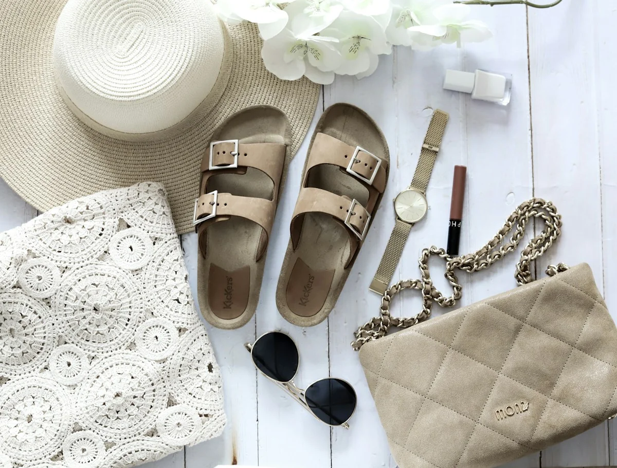 Neutral leather sandals styled with a woven hat and summer accessories